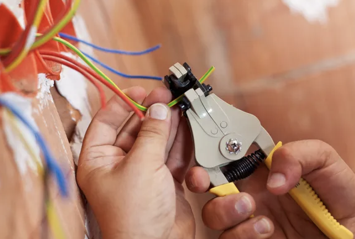 Main gantée travaillant sur un tableau électrique